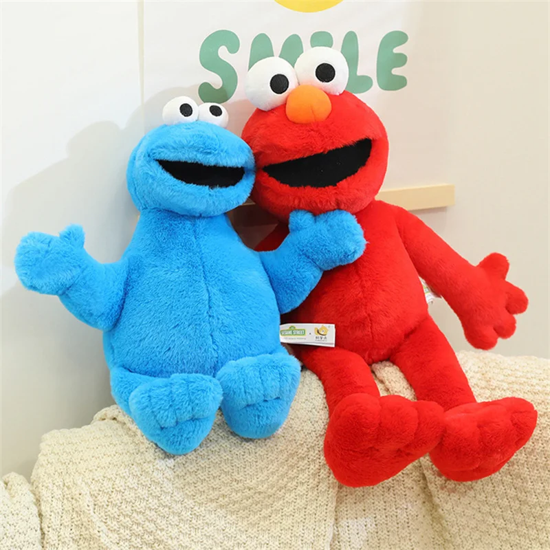 Sesame Street-karaktärer gosedjur, Blue och Early education, elmo bird cookie monster 32 Blått och rött mjukisdjur sitter bredvid varandra på en ljus filt.