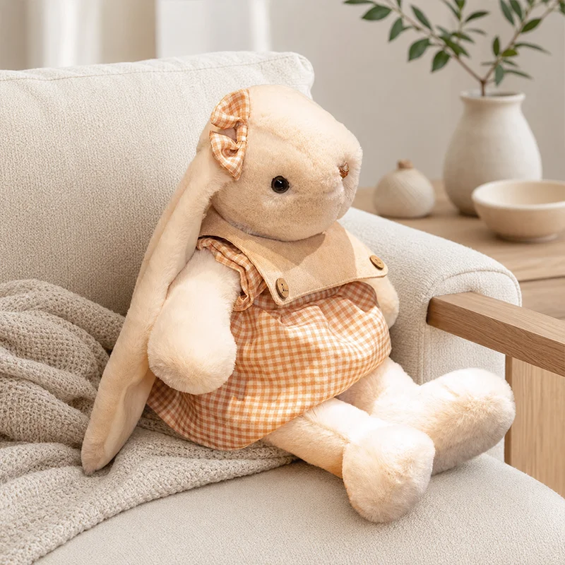 Kanin gosedjur i klänning, söt och charmig mjukisdocka som sovkompis, 45–55 cm 19 Kanindocka i orange rutig klänning sitter lutad mot en soffa.
