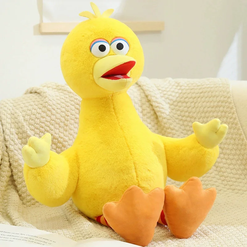 Sesame Street-karaktärer gosedjur, Blue och Early education, elmo bird cookie monster 31 Visa den gula fågeln sittande på en ljus, mönstrad filt.