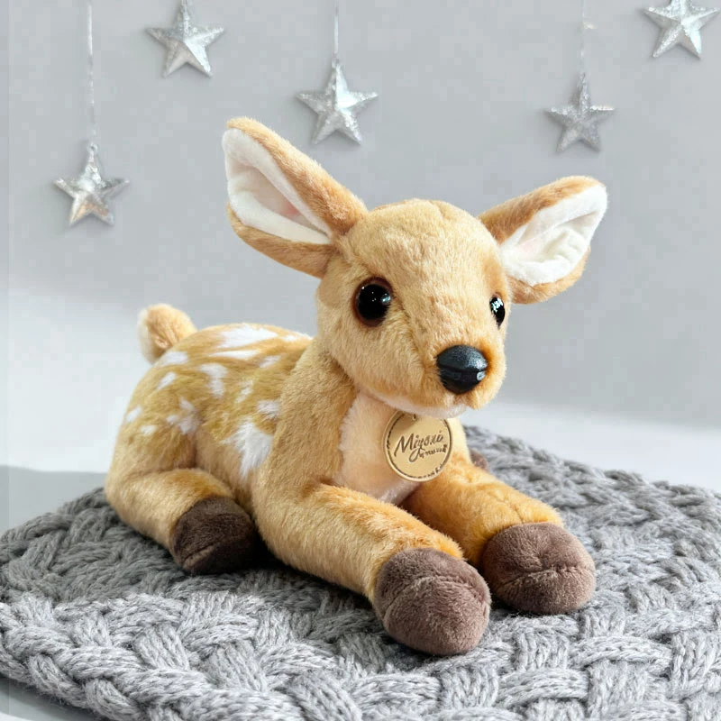 Hjort gosedjur, tecknad style och söt, mjukt fawn fawnfigur naturinspirerad, 25 cm 19 Visa fawnen sittande på en stickad filt med stjärnor i bakgrunden.