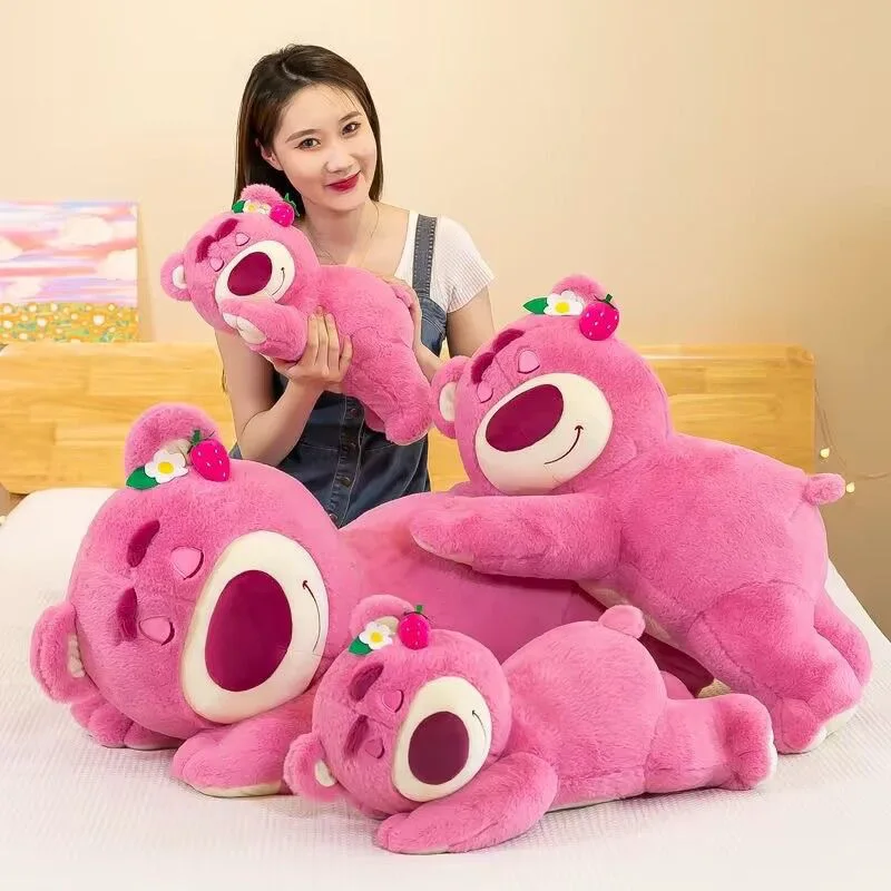 Disney Lotso björn gosedjur som jordgubbsinspirerad plyschkudde i tecknad stil 18 Visa de rosa björnplusharna i olika storlekar tillsammans med en person.